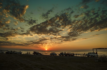 Beautiful blazing sunset landscape at Caspian sea and orange sky above it with awesome sun golden reflection on calm waves as a background. Amazing sunset view on the beach. Azerbaijan Absheron, Bakuの写真素材