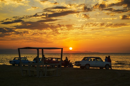 Beautiful blazing sunset landscape at Caspian sea and orange sky above it with awesome sun golden reflection on calm waves as a background. Amazing sunset view on the beach. Azerbaijan Absheron, Bakuの写真素材
