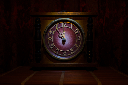 Time concept - vintage wood clock face with grunge texture at dark red maroon curtain background,の写真素材