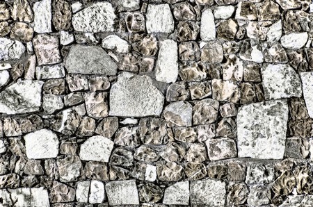 Fragment of old brick wall with river stones texture white grey brown black green blue lime yellow orange maroon violet pink turquoise colored background, different type of stones mosaic surfaceの写真素材