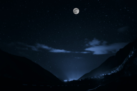 mountain river with stones and grass in the forest at the foot of mountain slope at night in moon light. Azerbaijan natureの写真素材