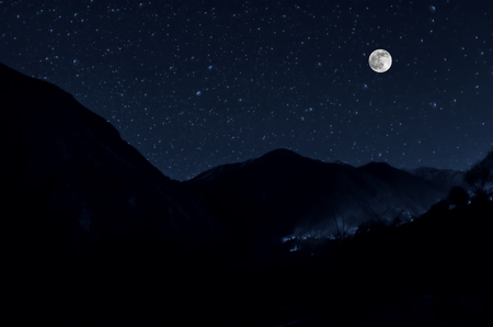 mountain river with stones and grass in the forest at the foot of mountain slope at night in moon light. Azerbaijan natureの写真素材