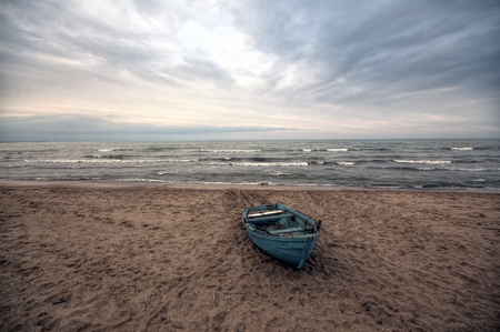 Beautiful landscape of Boat on the beach in cloudy weather. Vintage Boat in the seashore. Azerbaijan Caspian Seaの写真素材