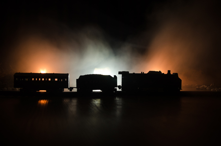 Train moving in fog. Ancient steam locomotive in night. Night train moving on railroad. orange fire background. Horror mystical sceneの写真素材