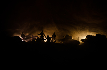 War Concept. Military silhouettes fighting scene on war fog sky background, World War Soldiers Silhouettes Below Cloudy Skyline At night. Attack scene. Armored vehicles. Tanks battleの写真素材