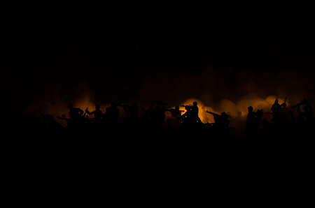War Concept. Military silhouettes fighting scene on war fog sky background, World War Soldiers Silhouettes Below Cloudy Skyline At night. Attack scene. Armored vehicles. Tanks battleの写真素材