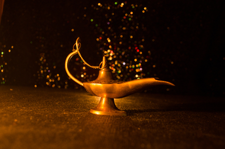 Antique Aladdin arabian nights genie style oil lamp with soft light white smoke, Dark background. Lamp of wishes conceptの写真素材