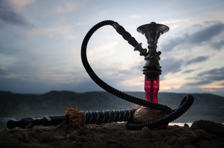 Hookah, traditional arabic waterpipe, direct sunset light, outdoor photo. Mountain backgroundの写真素材