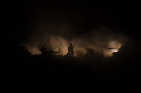 War Concept. Military silhouettes fighting scene on war fog sky background, World War Soldiers Silhouettes Below Cloudy Skyline At night. Attack scene. Armored vehicles. Tanks battleの写真素材