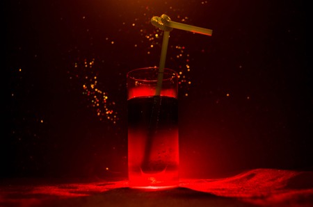Glass of Red Alcoholic Cocktail on Dark Background with smoke and backlight. Fire hot coctailの写真素材