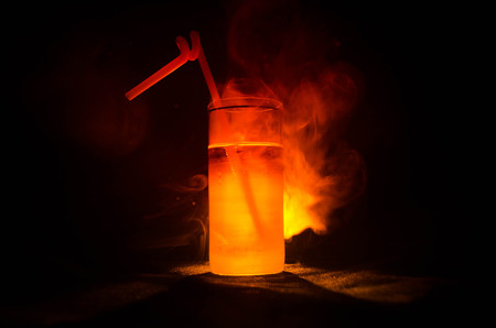 bright yellow green cocktail garnished with lime. Classic alcohol cocktails, cocktails at the bar, alcoholic drinks, soft drinks, tasty cocktails on dark background with smoke and lightの写真素材