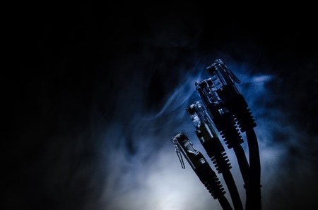 Network switch and ethernet cables, symbol of global communications. Colored network cables on dark background with lights and smoke. Selective focus. Network internet concept backgroundの写真素材