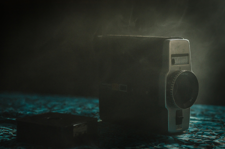 Classic vintage old 8mm movie camera on table with fog close up. Selective focusの写真素材