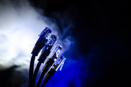 Network switch and ethernet cables, symbol of global communications. Colored network cables on dark background with lights and smoke. Selective focus. Network internet concept backgroundの写真素材