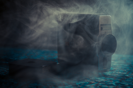 Classic vintage old 8mm movie camera on table with fog close up. Selective focusの写真素材