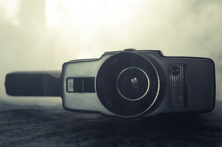 Classic vintage old 8mm movie camera on table with fog close up. Selective focusの写真素材
