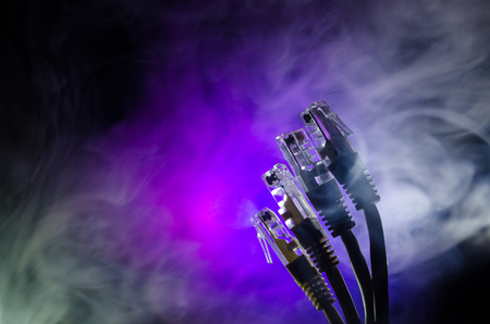 Network switch and ethernet cables, symbol of global communications. Colored network cables on dark...