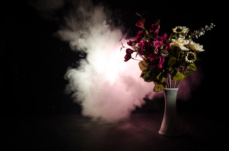 Picturesque purple spring flowers in glass vase standing in a row on a dark background with stars with light and fog. Flower concept with balloonの写真素材