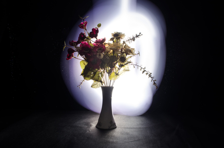 Picturesque purple spring flowers in glass vase standing in a row on a dark background with stars with light and fog. Flower concept with balloonの写真素材
