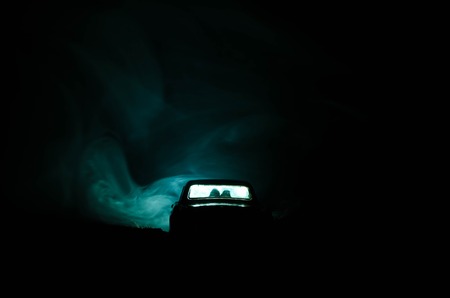 silhouette of car with couple inside on dark background with lights and smoke. Romantic sceneの写真素材