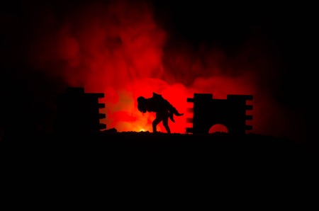 a silhouette of a man holding on to the woman. Rescue saviour concept. Escape from fire or danger. Surreal decorationの写真素材