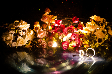 Wedding card, Wedding rings. Wedding bouquet, background. Flowering branch with white delicate flowers on wooden surface. Declaration of love, spring. Dark background with smoke and heart. Love coneptの写真素材