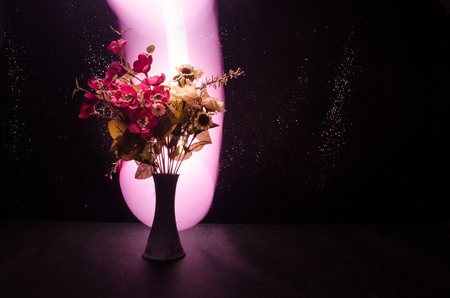 Picturesque purple spring flowers in glass vase standing in a row on a dark background with stars with light and fog. Flower concept with balloonの写真素材