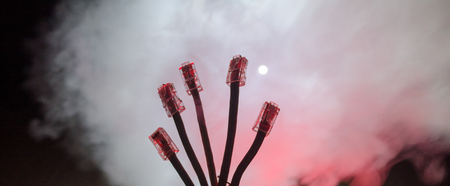 Network switch and ethernet cables, symbol of global communications. Colored network cables on dark background with lights and smoke. Selective focus. Network internet concept backgroundの写真素材