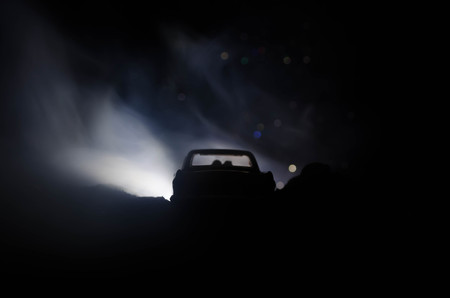 silhouette of car with couple inside on dark background with lights and smoke. Romantic sceneの写真素材