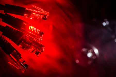 Network switch and ethernet cables, symbol of global communications. Colored network cables on dark background with lights and smoke. Selective focus. Network internet concept backgroundの写真素材