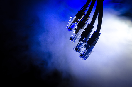Network switch and ethernet cables, symbol of global communications. Colored network cables on dark background with lights and smoke. Selective focus. Network internet concept backgroundの写真素材