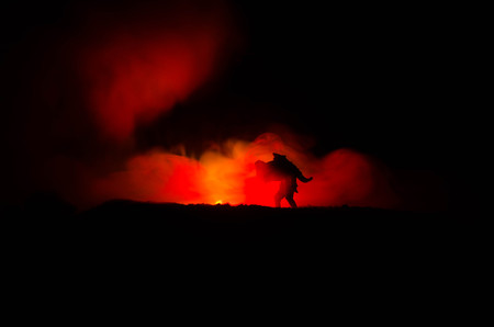 a silhouette of a man holding on to the woman. Rescue saviour concept. Escape from fire or danger. Surreal decorationの写真素材
