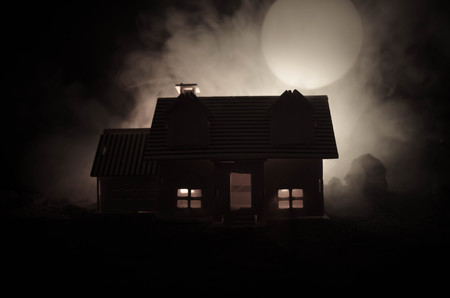Old house with a Ghost in the moonlit night or Abandoned Haunted Horror House in fog. Old mystic villa with surreal big full moon. Horror Halloween concept.の写真素材