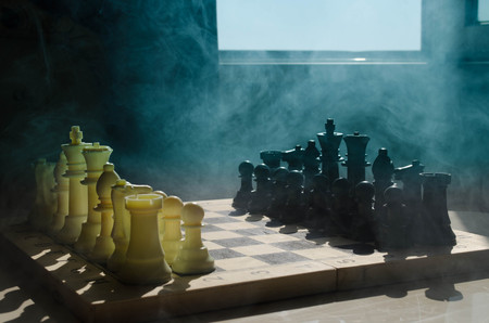 chess board game concept of business ideas and competition and strategy ideas concep. Chess figures on a dark background with smoke and fog. Selective focusの写真素材