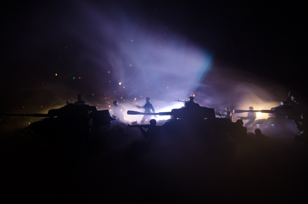War Concept. Military silhouettes fighting scene on war fog sky background, World War Soldiers Silhouettes Below Cloudy Skyline At night. Attack scene. Armored vehicles. Tanks battleの写真素材