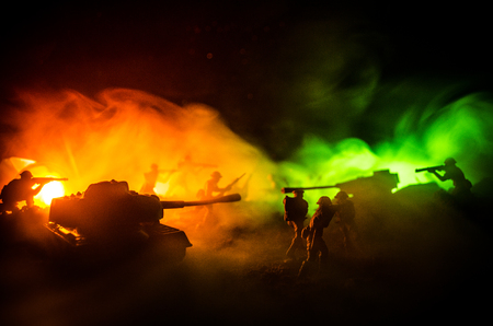 War Concept. Military silhouettes fighting scene on war fog sky background, World War Soldiers Silhouettes Below Cloudy Skyline At night. Attack scene. Armored vehicles. Tanks battleの写真素材