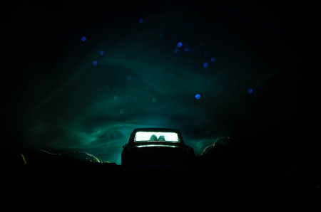 silhouette of car with couple inside on dark background with lights and smoke. Romantic sceneの写真素材