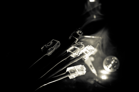 Network switch and ethernet cables, symbol of global communications. Colored network cables on dark background with lights and smoke. Selective focus. Network internet concept backgroundの写真素材