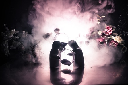 Two doll hugging on table with flowers and moon decoration Lighted background with smoke.Love...
