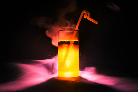 bright yellow green cocktail garnished with lime. Classic alcohol cocktails, cocktails at the bar, alcoholic drinks, soft drinks, tasty cocktails on dark background with smoke and lightの写真素材