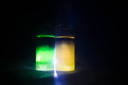 bright yellow green cocktail garnished with lime. Classic alcohol cocktails, cocktails at the bar, alcoholic drinks, soft drinks, tasty cocktails on dark background with smoke and lightの写真素材