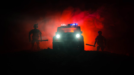 Anti-riot police give signal to be ready. Government power concept. Police in action. Smoke on a dark background with lights. Blue red flashing sirens. Dictatorship powerの写真素材