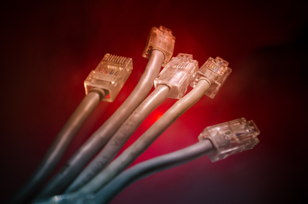 Network switch and ethernet cables, symbol of global communications. Colored network cables on dark background with lights and smoke. Selective focus. Network internet concept backgroundの写真素材