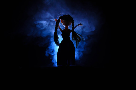 Silhouette of mysterious Woman, Horror scene of scary ghost doll woman on dark blue background with smokeの写真素材