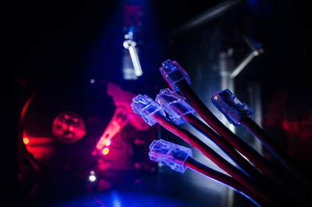 Network switch and ethernet cables, symbol of global communications. Colored network cables on dark background with lights and smoke. Selective focus. Network internet concept backgroundの写真素材