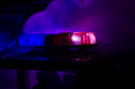 Red light flasher atop of a police car. City lights on the background.の写真素材