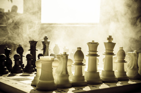 chess board game concept of business ideas and competition and strategy ideas concep. Chess figures on a dark background with smoke and fog. Selective focusの写真素材