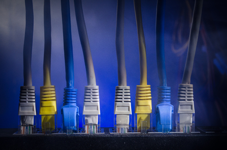 Network switch and ethernet cables, symbol of global communications. Colored network cables on dark...