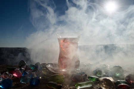 Turkish Azerbaijan tea in traditional glasse and pot outdoor nature background with sunlight and smoke. Eastern tea concept. Armudu traditional cup. Sunset timeの写真素材