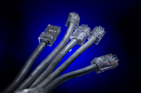 Network switch and lan cables, symbol of global communications. Colored network cables on dark...